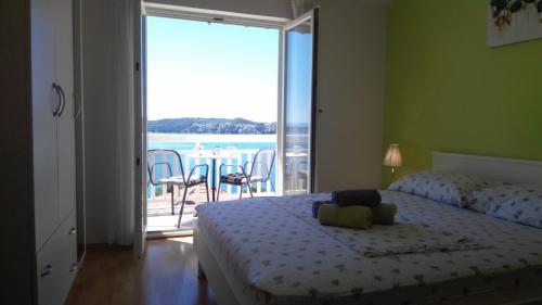 a bedroom with a bed and a view of the ocean at Apartments Zunic in Trogir