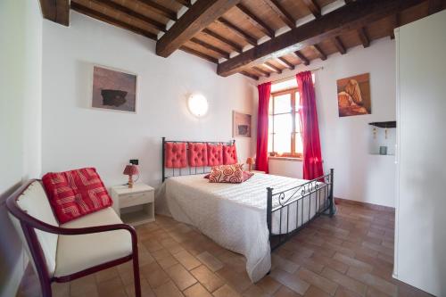 a bedroom with a bed and a chair and a window at Agriturismo e Glamping Serraiola Alta in Frassine