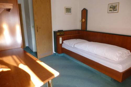 a bedroom with a bed with a wooden head board at Blaue Traube in Gebenbach