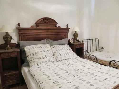 a bed with a wooden headboard and two night stands at Wohnen auf dem Wallwitzhof in Lutherstadt Wittenberg