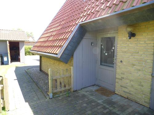 a brick house with a white door and a brown roof at Fräulein Emma Lotta in Kronsgaard