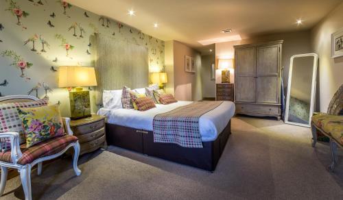 a bedroom with a large bed and a chair at The Huntsman Inn in Holmfirth