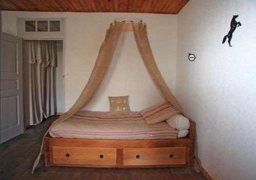 a bed with a canopy in a room at Le Gîte des Faucons in Faucon-de-Barcelonnette