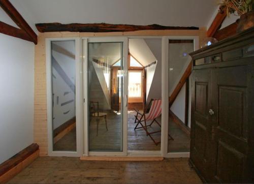 a room with sliding glass doors and a staircase at Le Gîte des Faucons in Faucon-de-Barcelonnette