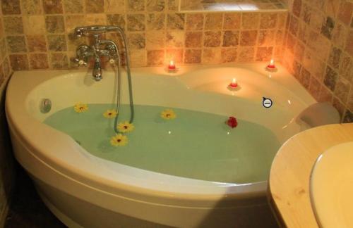a bathroom with a bath tub with candles in it at Le Gîte des Faucons in Faucon-de-Barcelonnette