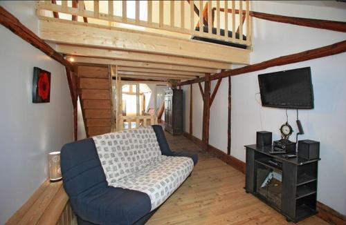 a living room with a couch and a flat screen tv at Le Gîte des Faucons in Faucon-de-Barcelonnette