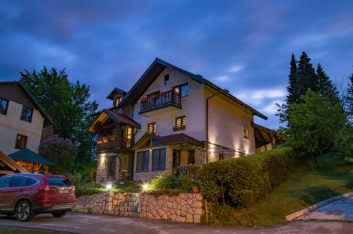 a house with a car parked in front of it at Apartments Josipovic in Zlatibor