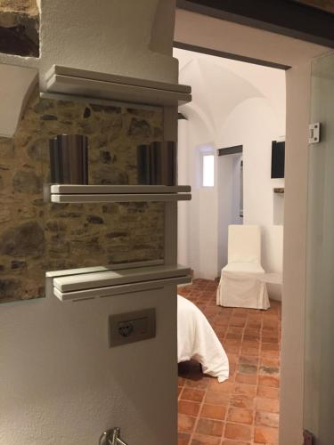a room with a stone wall and a room with a bed at A Ca Du Barba Ge in Vallebona