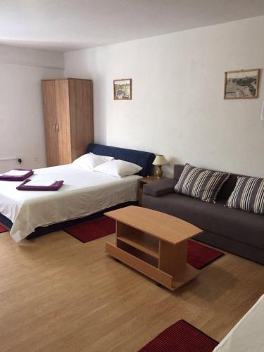 a living room with a bed and a couch at Crveno Zlato in Biograd na Moru