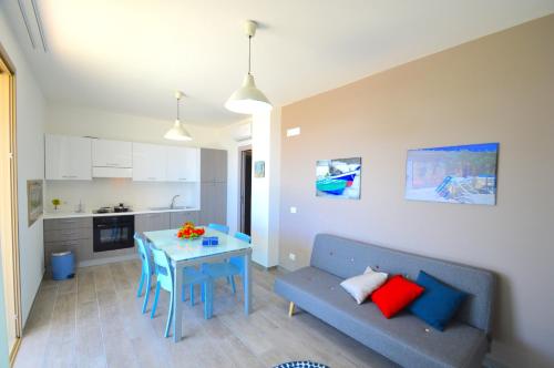 a living room with a blue couch and a table at Yachting Apartment in Marzamemi