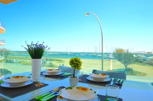 a dining table with a view of a golf course at Yachting Apartment in Marzamemi