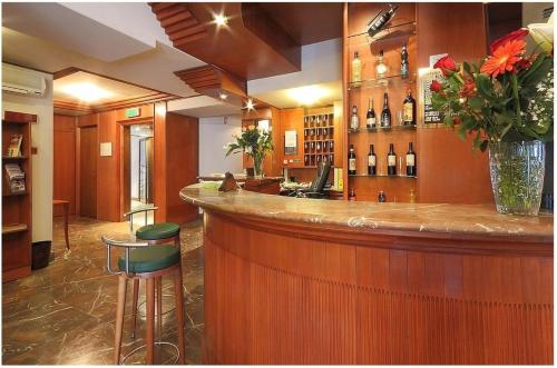 a bar with a vase of flowers and wine bottles at Hotel Arcadia in Florence