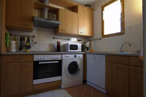 una cucina con lavatrice e forno a microonde di Le Port Mesnil a Mesnil-Saint-Père