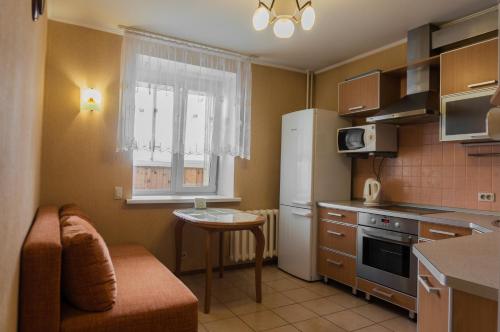 キーロフにあるApartments in Kirov on Maklinaの小さなキッチン(テーブル、冷蔵庫付)