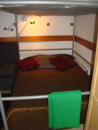 a small room with a bed and a green towel at Tejo Apartment in Lisbon