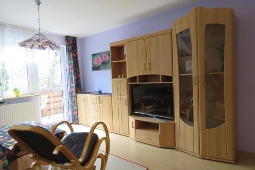 a living room with a large wooden cabinet and a tv at Stollenklause in Hormersdorf