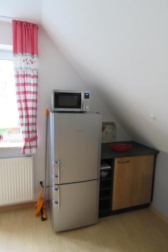 a kitchen with a refrigerator and a microwave on top of it at Stollenklause in Hormersdorf
