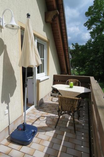 a patio with a table and a umbrella and a table and chairs at Stollenklause in Hormersdorf