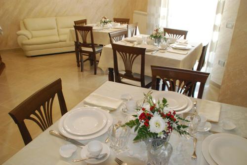 un comedor con mesas y sillas con flores. en Daphnae House, en Palma di Montechiaro