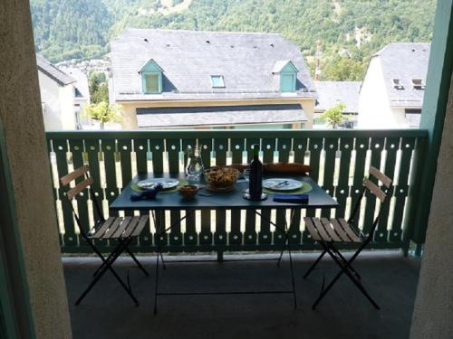 une table avec des assiettes de nourriture sur un balcon dans l'établissement Chalet De Peyrelance, à Cauterets