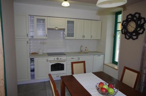 a kitchen with white cabinets and a table with a bowl of fruit at Vilka Marticus in Frenštát pod Radhoštěm