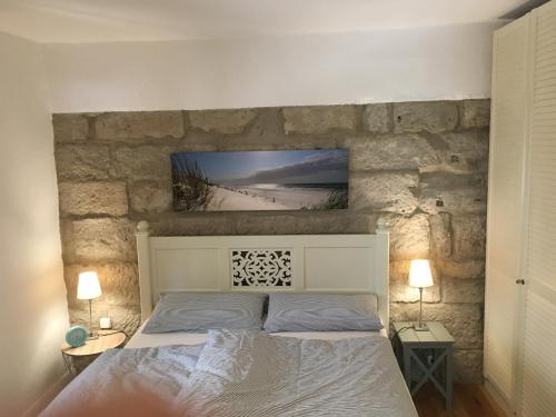 a bedroom with a bed with a stone wall at Ferienwohnung Ankerplatz in Rieden