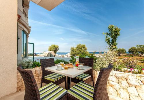 a table and chairs on a balcony with a view of the ocean at Apartments Ruzmarin in Lun