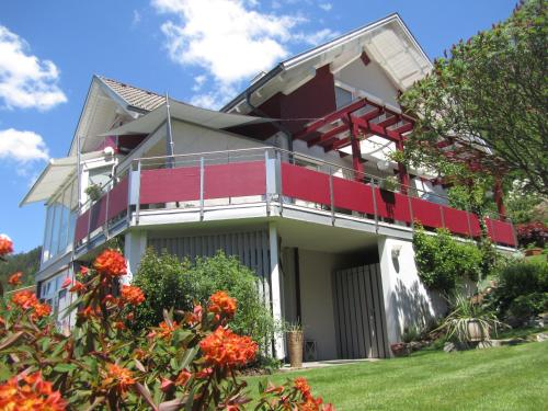 ein Haus mit einem Balkon mit Orangenblüten in der Unterkunft Südhang FeWo in Murau