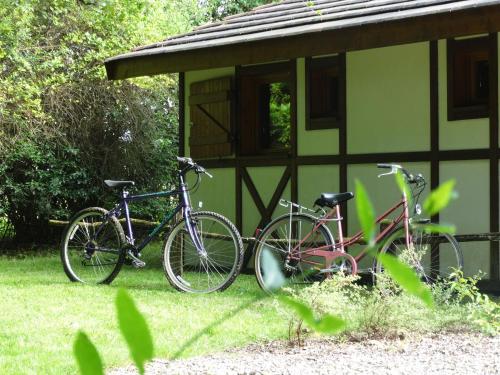 deux vélos garés devant un bâtiment dans l'établissement Chalets du pontot, à Le Fay