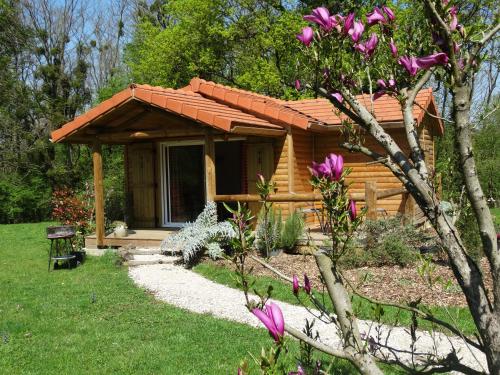 a small wooden cabin with a porch in a yard at Chalets du pontot in Le Fay