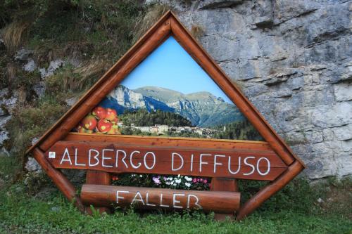 a sign that says albergo diffusico and a mountain at Albergo Diffuso Faller in Faller