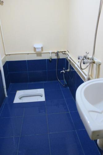 a blue tiled bathroom with a toilet and a sink at Ancient Lahij Guest House in Lahıc