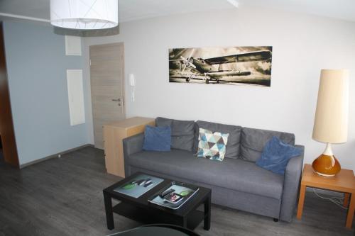 a living room with a couch and a table at L'ARBOGAST in Herrlisheim