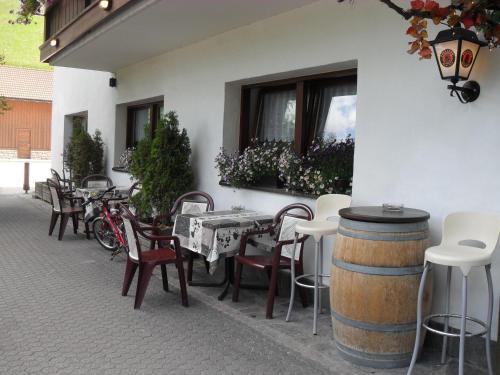 a patio with a table and chairs and a barrel at Hotel Casa Alpina - Alpin Haus in Selva di Val Gardena