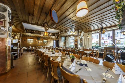 a dining room with long tables and chairs at Hotel & Gasthof Fraundorfer in Garmisch-Partenkirchen