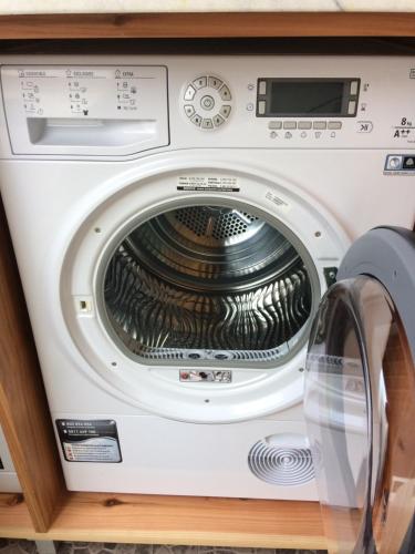 a washing machine in a cabinet with its door open at Vale dos Cocos in Horta