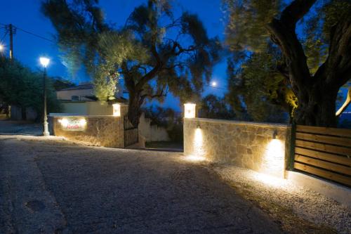 a street at night with lights on a wall at Renata Rooms & Studios in Barbati
