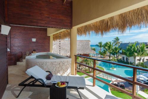 a balcony with a hot tub and a view of the ocean at Zoetry Agua Punta Cana - All Inclusive in Punta Cana
