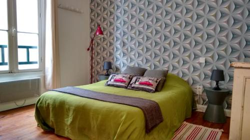 a bedroom with a green bed with two pillows at Bakia in Biarritz