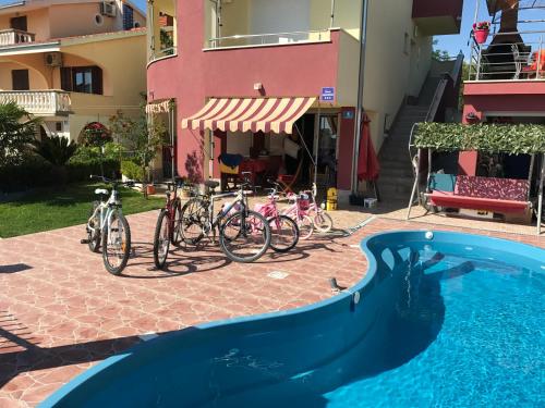 un grupo de bicicletas estacionadas junto a una piscina en Apartments Villa Stella Maris, en Rogoznica