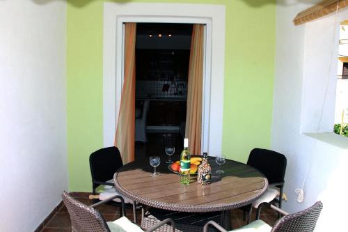 a dining room with a table with wine glasses at Apartments Villa Russo in Tisno