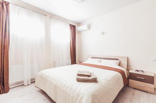 a white bedroom with a bed and a window at Apartments near Deribasovskaya in Odesa