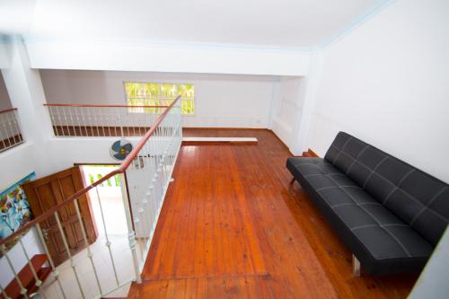 a living room with a couch and a staircase at Las Palmeras by Graziano in Boca Chica