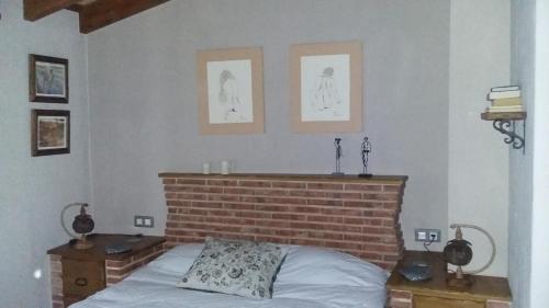 ein Schlafzimmer mit einem Bett und zwei Bildern an der Wand in der Unterkunft Dayma in Medina-Sidonia