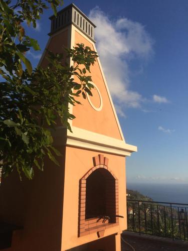 a small clock tower sitting on the side of a building at Quinta Paços do Lago in Funchal