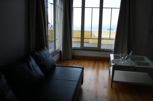 a living room with a couch and a table and a window at Quinta Paços do Lago in Funchal