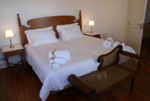 a bedroom with a large bed with white sheets and towels at Quinta Paços do Lago in Funchal