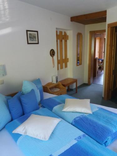 - un lit avec des draps et des oreillers bleus dans l'établissement Haus Raimund " KLEIN aber FEIN ", à Alpbach