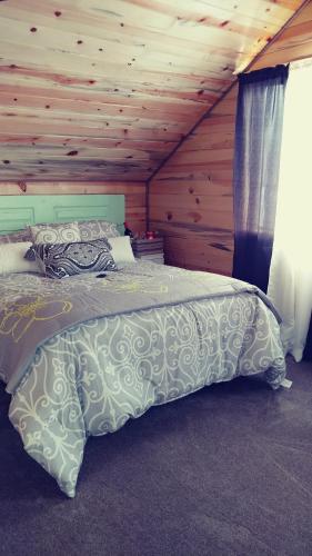 Cama en habitación con techo de madera en Wonder Inn Outback, en Panguitch