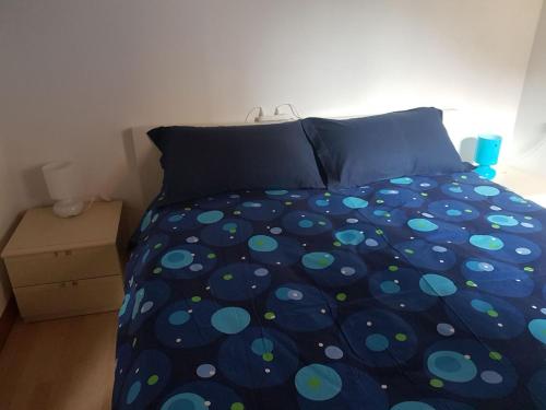 ein Schlafzimmer mit einem Bett mit einer Polka-Dot-Tagesdecke in der Unterkunft Casa Muffin 3 in Cannobio